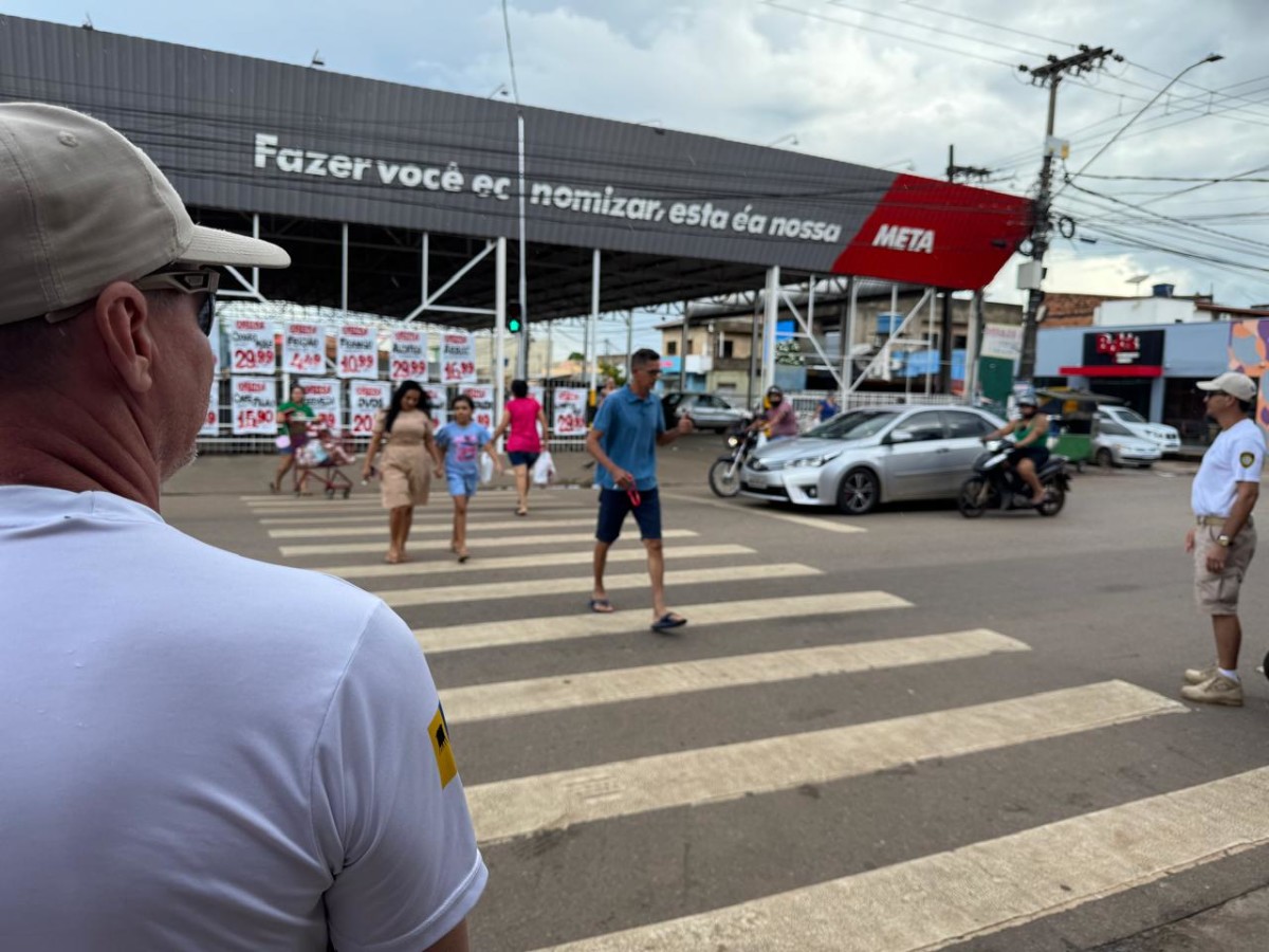 Pedestres atravessam faixa sinalizada com apoio da Semtran em área comercial de Porto Velho