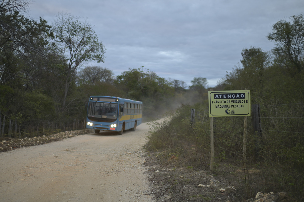Ônibus transportando trabalhadores pela estrada de terra próxima à mineradora.