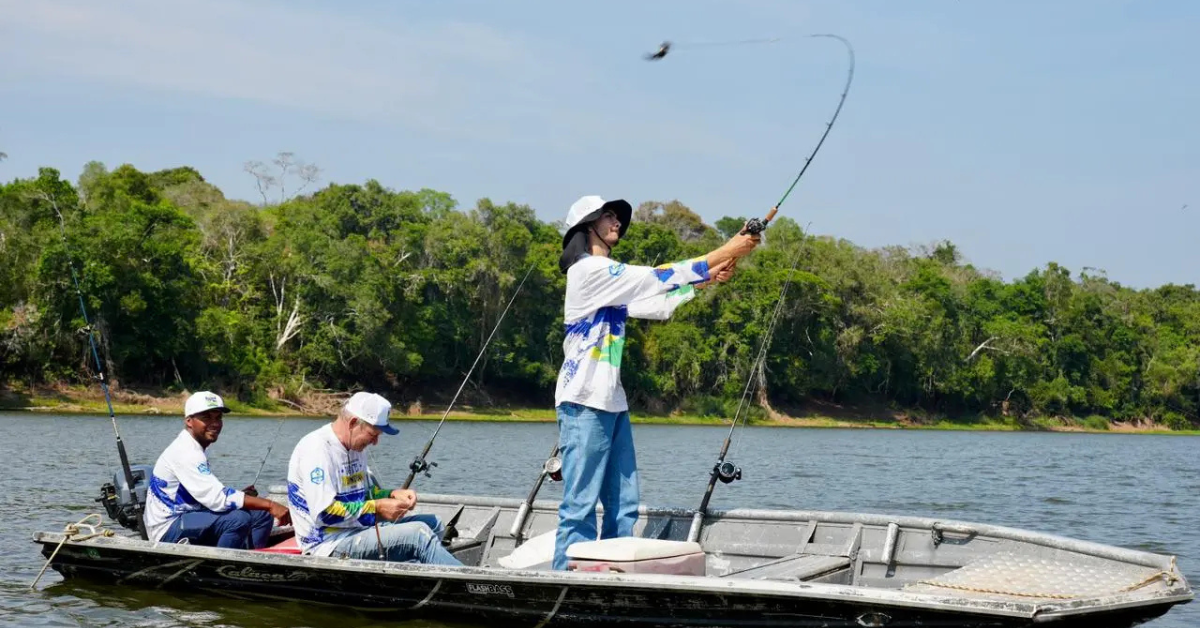Participantes praticam pesca esportiva em embarcação durante ação turística em rio de Rondônia
