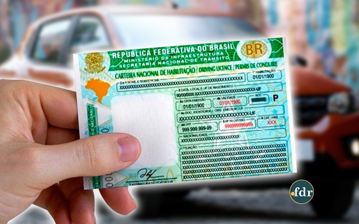 Pessoa segura uma Carteira Nacional de Habilitação (CNH) brasileira com fundo desfocado de carro