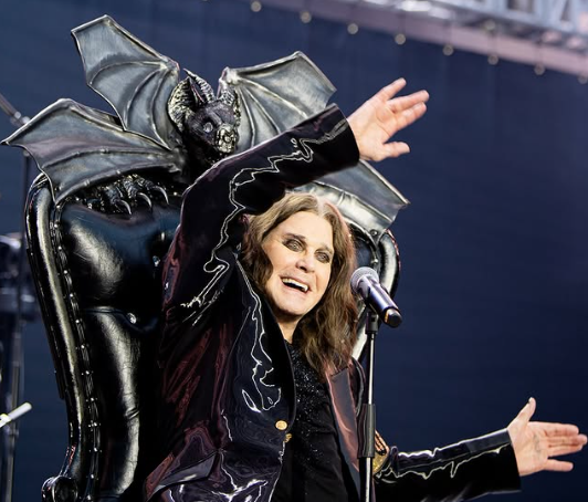 Ozzy Osbourne sorri em palco, sentado em trono com gárgula, durante apresentação em 2025