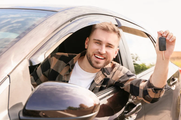 Homem sorridente segura chave de carro enquanto dirige, simbolizando conquista da CNH