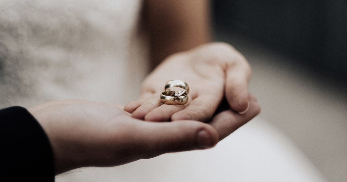 Detalhe das mãos de um casal usando alianças, representando a oficialização da união no Casamento Comunitário Porto Velho 2025.