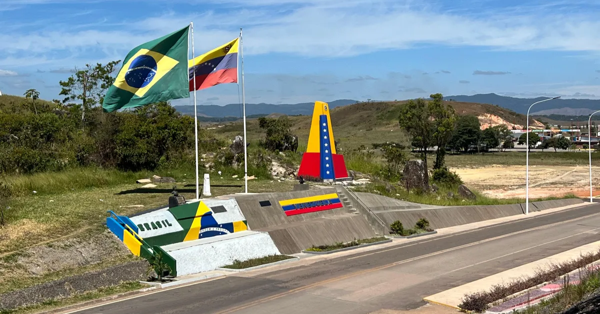 Fronteira entre Brasil e Venezuela em Pacaraima com bandeiras hasteadas e monumentos coloridos dos dois países