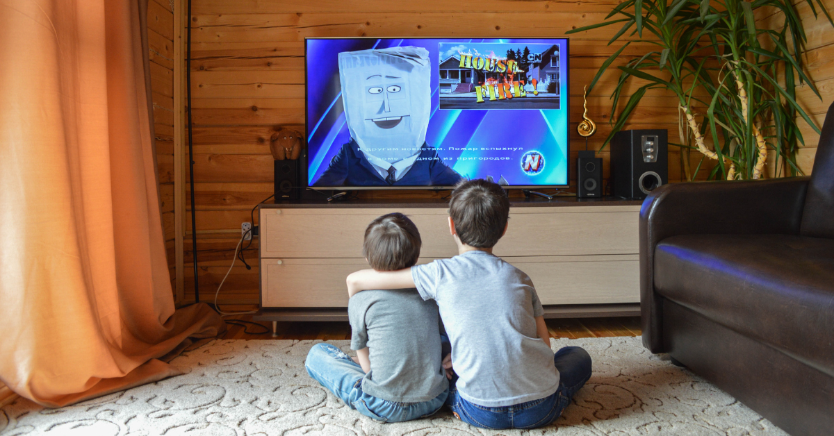 Crianças assistindo televisão em sala de estar, representando a chegada da TV 3.0 e seus novos recursos interativos.