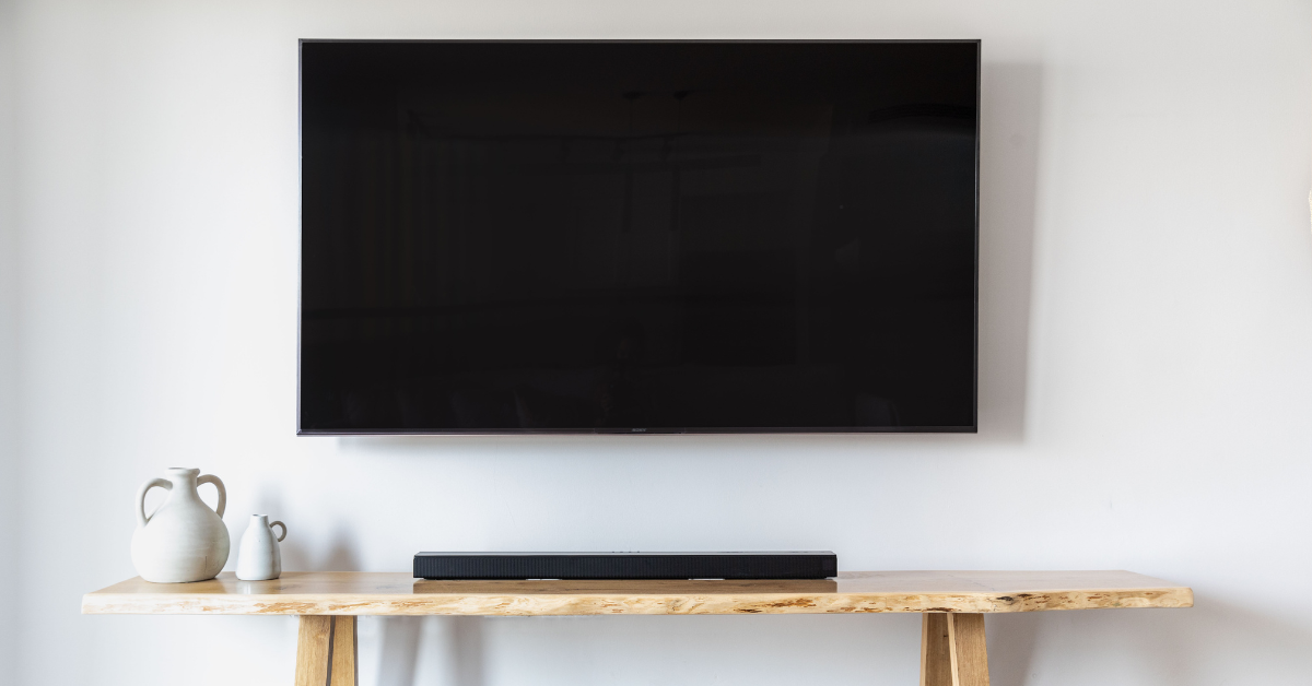 Televisor moderno em parede com soundbar, representando a chegada da TV 3.0 e a necessidade de conversor inicial.