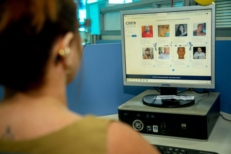 Servidor observa tela com lista de pessoas desaparecidas no sistema do CNPD