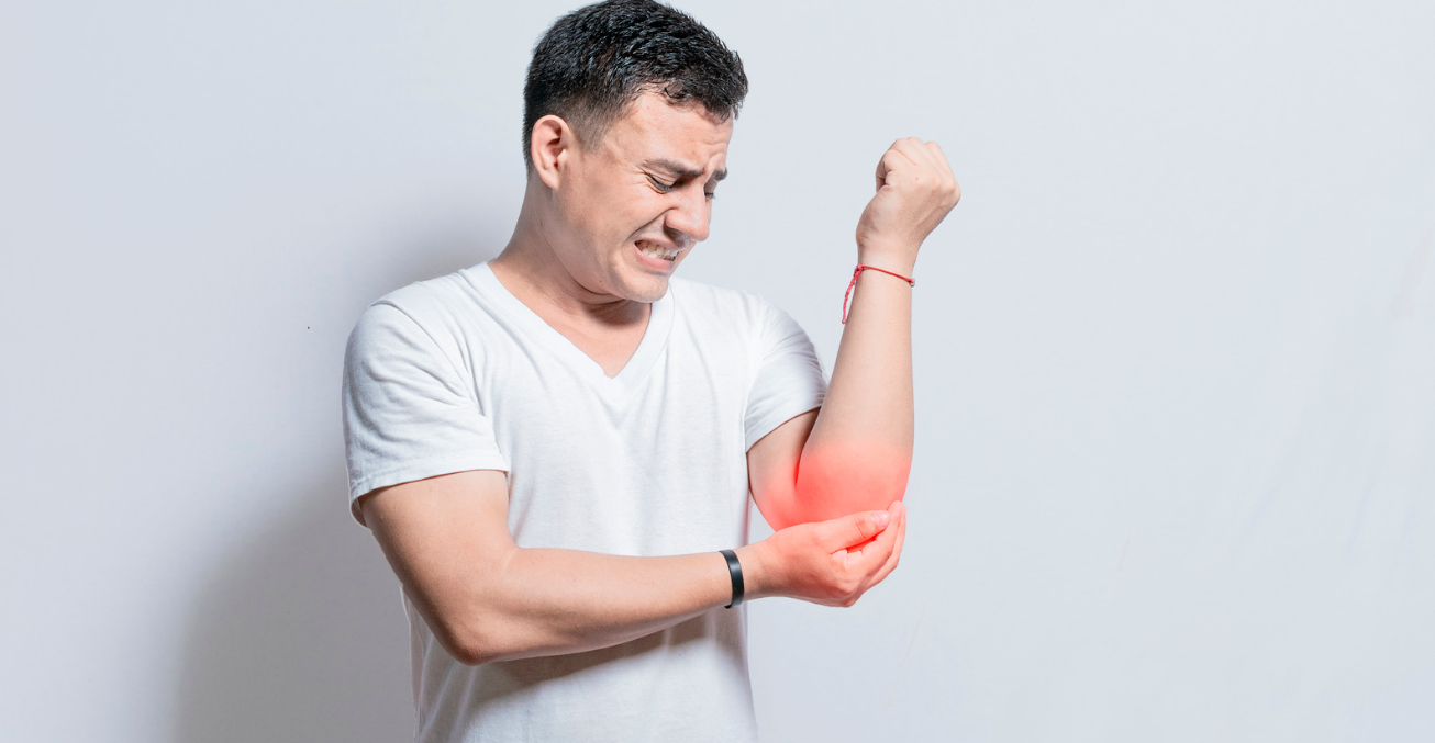 Homem com dor no braço esquerdo e expressão de desconforto, indicando dormência ou compressão nervosa