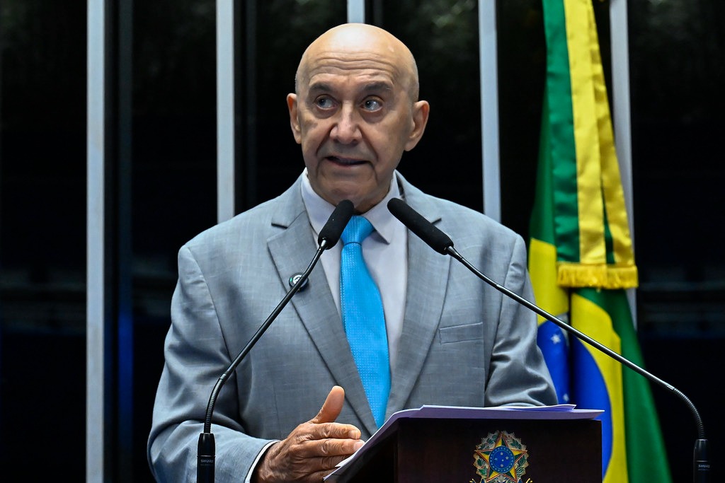 Senador Confúcio Moura discursa na tribuna do Senado Federal, com bandeira do Brasil ao fundo, defendendo mais investimentos na educação pública.